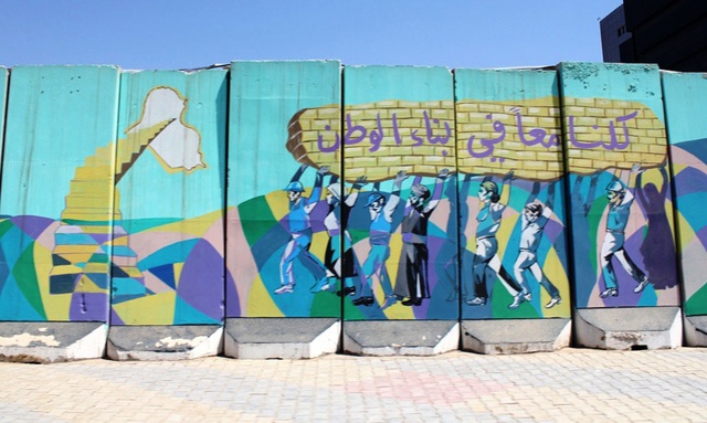 Mural in front of the Ministry of Public Works, in Karkh. It reads: 'Let's all build the nation together'.