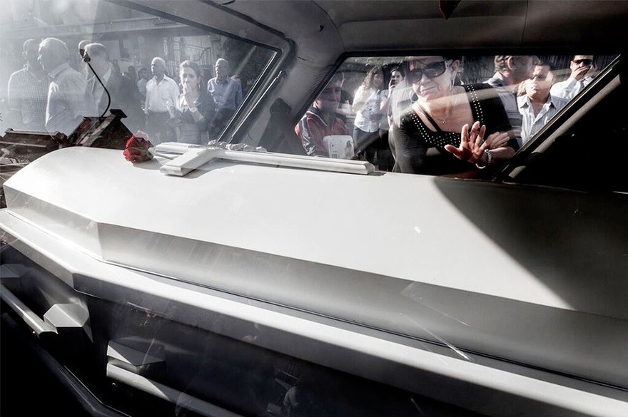 Carole Alfarah. People surround the hearse transporting the coffin of 19-year-old Maria Kahla, who was killed with her father and her two friends in a suicide car bombing as they were heading to university early morning in a Damascus neighborhood. Damascus, Syria, 2012.