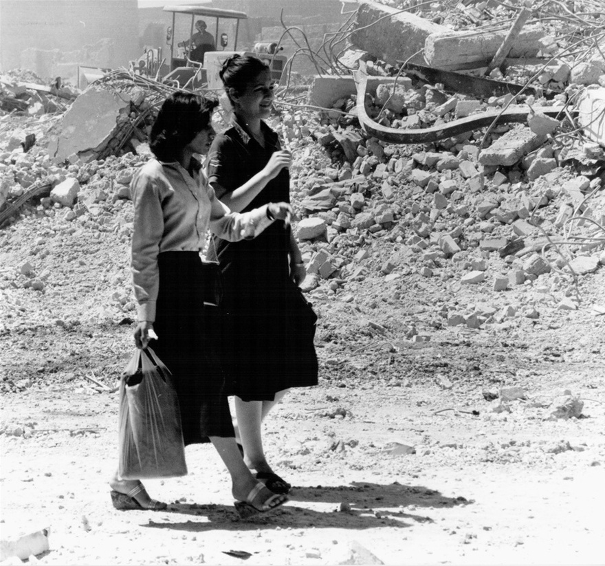 Photograph from the Chadirji collection showing women passing by rubble of the demolished area soon to become the Haifa Street development.