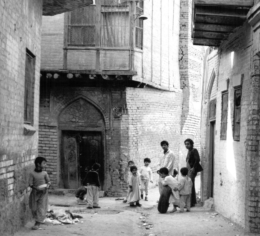 Photograph from the Chadirji collection showing children playing at a derelict alley of an old Baghdadi neighborhood.
