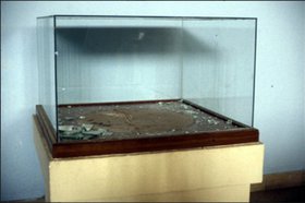 Bassetki statue's display case, with its side smashed.