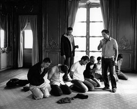 Reza Aramesh, Action 51, Kerem Shalom, Israel, February 17, 2008. Palestinian prisoners sit blindfolded on the ground after they were capture by Israeli soldiers, 2008, black and white silver gelatin print, 124 x 157 cm. 