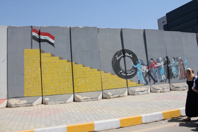 Murals in front of the Ministry of Public Works, in Karkh. It reads: 'The Wheel of Progress'.