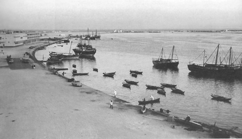 The Deira side of Dubai Creek in 1964, after reclaimed land had been added to the shore. Dhows were offloaded by smaller vessels. Port Saeed would be developed further upshore in photograph's background. 