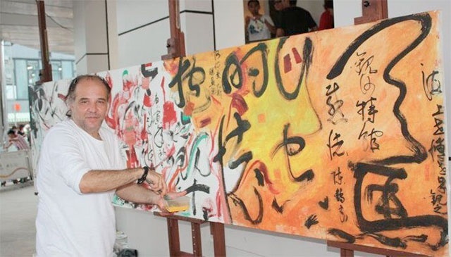 Ayman Yossri Daydban in front of an Arabic-Chinese calligraphy performance at the Saudi Arabian Pavilion, 2010 Shanghai World Expo, China. Performed by Shadia and Raja Alem, Ayman Yossri Daydban and Chinese calligraphy master Chen Heliang.
