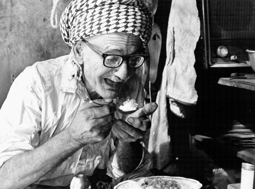 Photograph from the Chadirji collection showing traditional silversmith taking a lunch break, Baghdad.