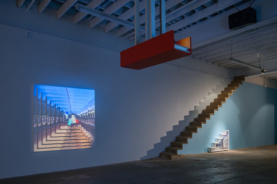 Meriem Bennani, View from Gradual Kingdom show. L to R: Gradual Kingdom (two-projection mapped digital videos on styrofoam screens with sound), Plage, Escalier (sand stairway), Cab Ride (photograph in stairway shaped frame), 2015.